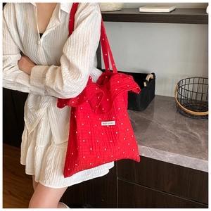 Detail of red floral ruffle tote bag in seersucker fabric with Magic pocket tag