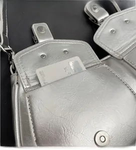 Detailed close-up of a silver metallic shoulder bag showing a functional pocket with a card