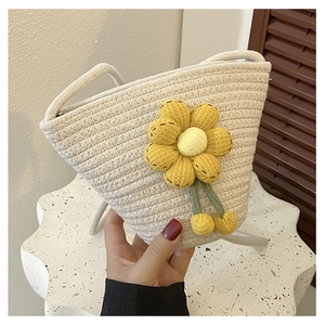 Detail of hand-woven beige mini bucket bag with yellow sunflower and rope strap