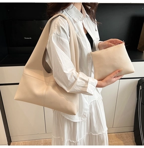 Detail view of cream lychee texture leather tote bag with matching zippered pouch insert