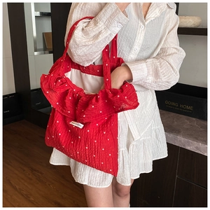Detail of red floral chiffon tote bag featuring ruffle trim and Magic pocket label