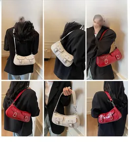 Detail view of stylish underarm bags in red and beige with silver buckle pockets