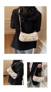 Detail of white crescent underarm bag with double utility pockets and metallic buckle strap