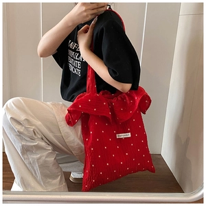 Detail of red floral chiffon tote bag with ruffle edge and Magic Pocket label