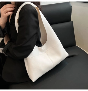 Detail view of white soft leather tote bag with elegant pebble grain and stitching texture