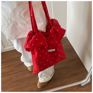 Detail of red ruffled chiffon tote bag with floral pattern and Magic Pocket logo