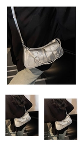 Detail view of silver faux leather underarm bag with double buckle pockets and long strap