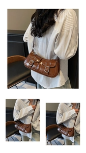 Detail of a brown vintage underarm bag featuring silver metal buckles and dual front pockets