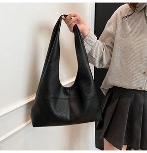 Detail of black pebbled leather tote bag featuring contrast stitching and Hobo silhouette