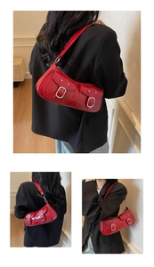 Detail of red patent leather underarm bag with functional double pockets and silver buckles