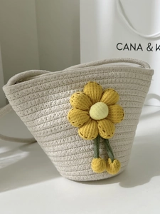 Cute cream bucket bag with a large yellow sunflower and woven crossbody strap