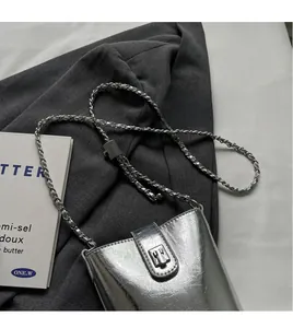Close-up of silver textured bucket bag with leather chain strap and metallic buckle