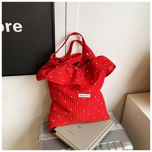 Detail of red ruffle tote bag with star pattern and Magic Pocket woven label