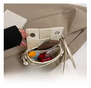 Detail of woven beige leather handbag showing magnetic buckle and interior storage capacity