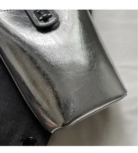 Close-up of trendy silver bucket bag showing pleated metallic texture and metal buckle