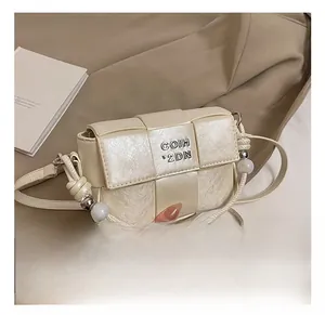 Close-up of cream woven texture small crossbody bag with metal logo and bead strap details