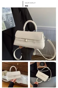 Detail view of off-white crossbody bag with top handle and elegant metal buckle