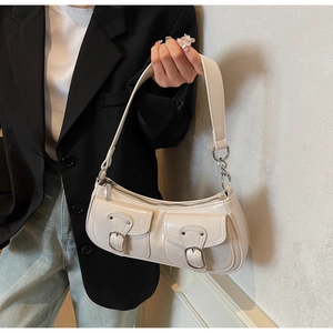 Chic cream leather baguette shoulder bag with multiple front utility pockets and silver hardware