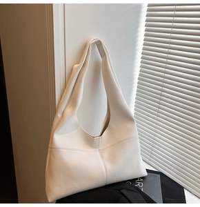 Detailed macro view of the premium lychee pattern texture on this soft cream tote bag
