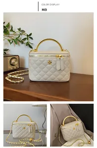 Close-up of beige quilted vanity bag with golden metal handle and flower logo