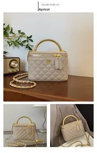 Detail of apricot quilted bucket bag with golden camellia clasp and metal handle