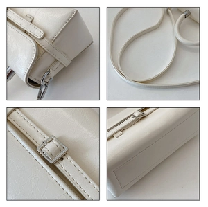 Close-up of off-white textured leather handbag with silver hardware and adjustable strap