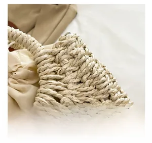 Close-up of tight raffia weave texture and durable handle connection on straw bag