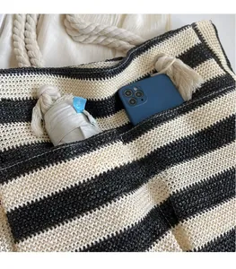 Close-up of the spacious interior compartment of a striped woven tote bag with a phone