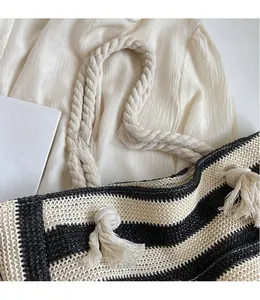Detail of black and white striped woven tote with thick cotton rope handle and tassel knots