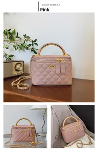 Detailed view of pink quilted leather box bag with golden handle and camellia logo