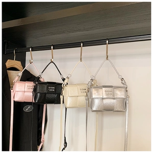 Detail view of woven mini crossbody bags in pink, black, cream, and silver colors