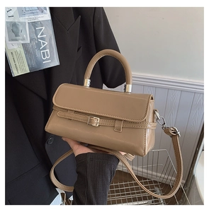 Close-up of warm brown PU leather handbag with silver buckle and sleek magnetic closure