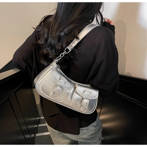 Detail of silver Y2K metallic shoulder bag featuring functional multi-pockets and chain strap
