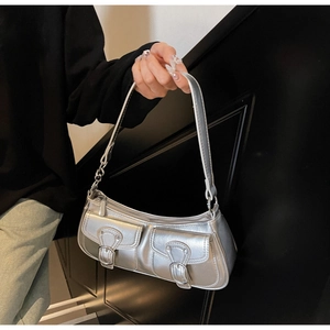 Detail view of metallic silver Y2K shoulder bag featuring dual front buckle pockets