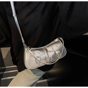 Silver metallic shoulder bag with utility pockets shown in a stylish street style pose
