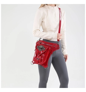 Détail d'un sac banane punk rouge montrant le cuir verni brillant et le crâne argenté