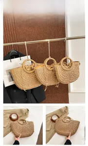 Detail view of the brown straw handbag with woven ring handles and drawstring inner lining