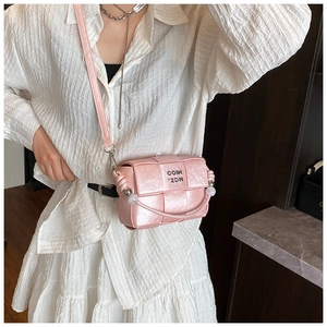 Detailed macro view of pink woven texture bag with pearl handle and silver metal logo