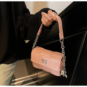 Détail du sac bandoulière tissé rose avec chaîne argentée et pendentif lapin
