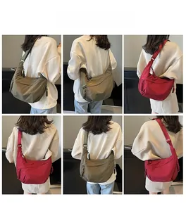 Detail of adjustable straps and zipper pulls on burgundy and army green crossbody bags