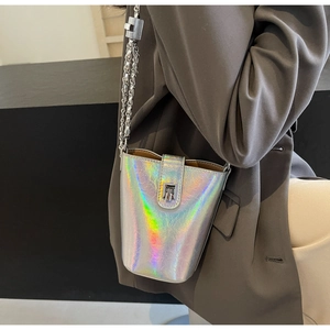 Detail of silver holographic bucket bag with metal chain strap and turn-lock closure