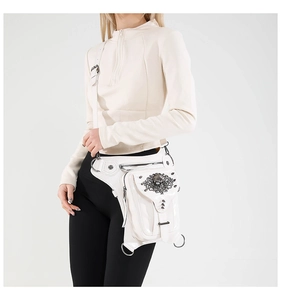 Détail de la sacoche de jambe punk en cuir blanc avec badge tête de mort et rivets