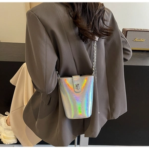 Iridescent silver laser bucket bag with metal chain strap shown as a crossbody on model