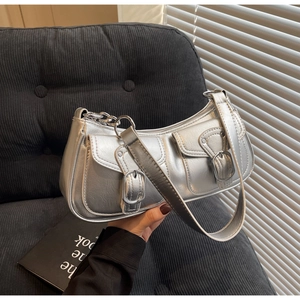 Detail view of silver Y2K underarm bag featuring dual front pockets and metal buckle hardware