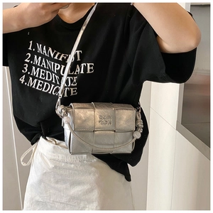 Detail of silver woven crossbody bag with metallic finish and letter embossing