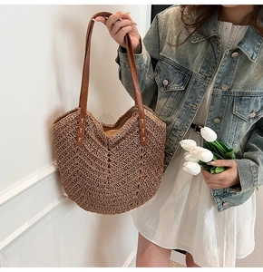 Close-up of V-shaped weaving texture and leather strap on a summer straw tote bag