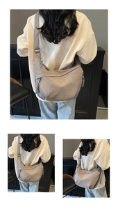 Detail view of grey nylon dumpling bag showing adjustable strap and woven paracord zipper pull