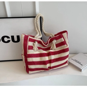 Detail of red and white striped woven tote bag featuring thick rope handles and side pocket
