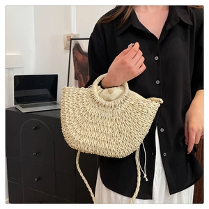 Detail of hand-woven straw bag with round handles and practical drawstring inner liner