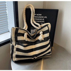Detail of woven tote bag featuring black and white stripes and thick cotton rope handles